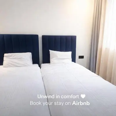 two beds with white sheets and a blue headboard at New comfy appartement-centre -Menara-Gueliz-aero in Marrakech
