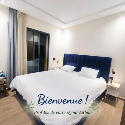 a bedroom with a large bed with a blue headboard at New comfy appartement-centre -Menara-Gueliz-aero in Marrakech