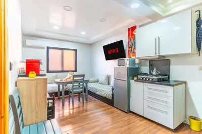 a kitchen with a refrigerator and a table in a room at Heart of Gueliz - Nice 2BR Flat near Train Station in Marrakech
