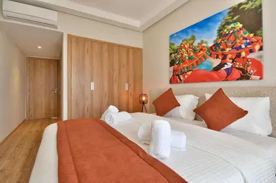 a bedroom with a large white bed with a painting on the wall at Marrakech Luxury 2BR Pool View and Terrace for Remote Work in Marrakech