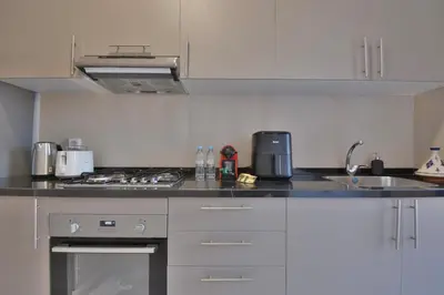 a kitchen with white cabinets and a counter top at Marrakech Luxury 2BR Pool View and Terrace for Remote Work in Marrakech