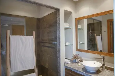 a bathroom with a shower and a sink and a mirror at Elegant 3-BR Villa with breakfast included in Marrakech