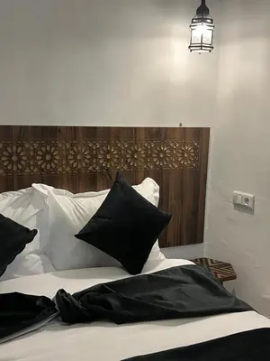 a bed with black and white pillows on it at Riad Lalla Nadia in Marrakech