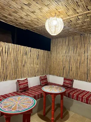 a room with a couch and two tables and a chandelier at Riad Lalla Nadia in Marrakech