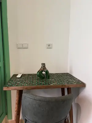a table with a chair and a green and white table at Riad Lalla Nadia in Marrakech