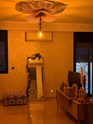 a living room with a ceiling fan and a mirror at Charming Bohemian hideaway in Marrakech in Marrakech