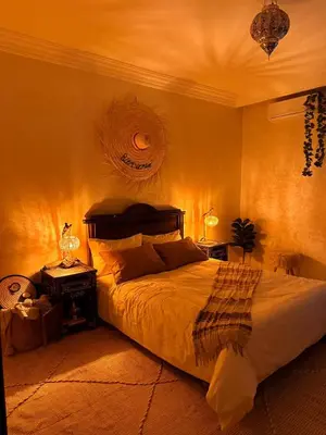 a bedroom with a large bed and a night stand with a lamp at Charming Bohemian hideaway in Marrakech in Marrakech