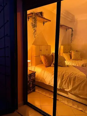 a mirror in a bedroom with a bed and a lamp at Charming Bohemian hideaway in Marrakech in Marrakech