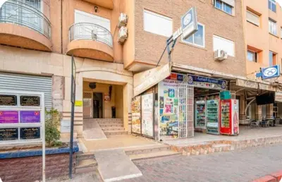 a building with shops on the side of a street at Au Cœur de L'hivernage P09 in Marrakech