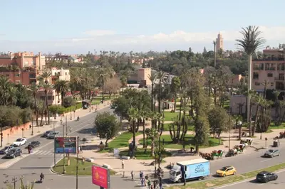 a street in a city with cars and trees at Appartement plein centre marrakech p in Marrakech