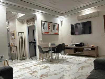 a living room with a table and chairs at Appartement plein centre marrakech p in Marrakech