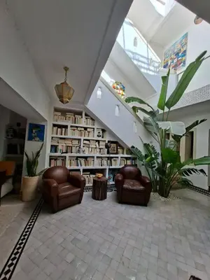 a living room with two chairs and a staircase at Riad Millefeuilles in Marrakech