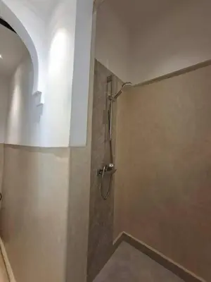 a bathroom with a shower with a wall at Riad Millefeuilles in Marrakech