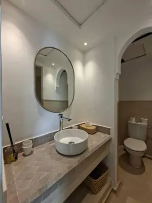 a bathroom with a sink and a toilet and a mirror at Riad Millefeuilles in Marrakech
