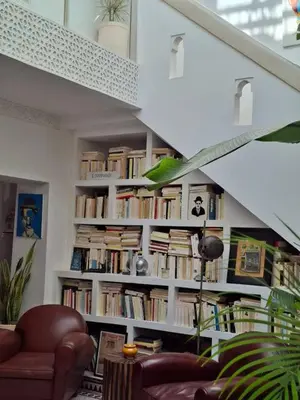 a living room with a book shelf filled with books at Riad Millefeuilles in Marrakech