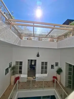 a building with a balcony with a swimming pool at Riad Millefeuilles in Marrakech