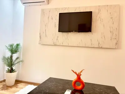 a living room with a tv on a wall at F2 Cozy and Swimming pool in Marrakech