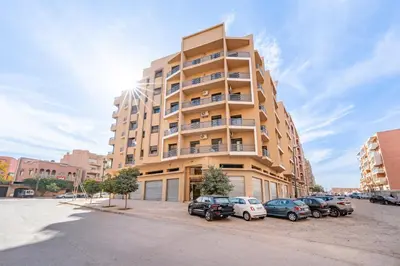 a tall building with cars parked in front of it at F2 Cozy and Swimming pool in Marrakech
