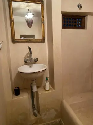 a bathroom with a sink and a mirror and a tub at l'oasis de Bab Ghmat in Marrakech
