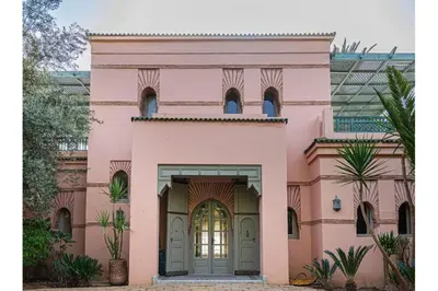 a pink house with a large door at Villa Soleil Private Pool & Garden in Marrakech
