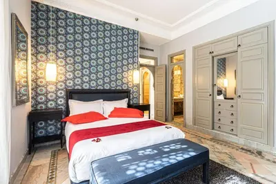 a bedroom with a large bed with red pillows at Villa Soleil Private Pool & Garden in Marrakech