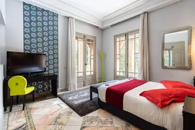 a bedroom with a bed and a tv and a mirror at Villa Soleil Private Pool & Garden in Marrakech