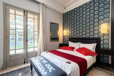 a bedroom with a large bed with red pillows at Villa Soleil Private Pool & Garden in Marrakech