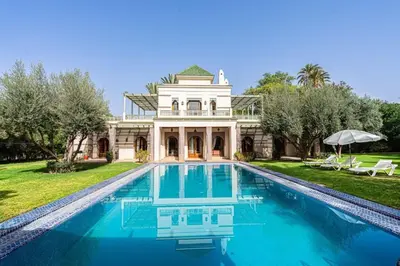 a large house with a swimming pool in front of it at Palmeraie Collection Villa & Piscine in Marrakech