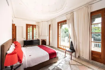 a bedroom with a large bed with a red blanket at Palmeraie Collection Villa & Piscine in Marrakech