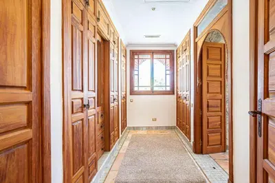 a hallway with wooden doors and a window at Palmeraie Collection Villa & Piscine in Marrakech