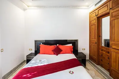 a bedroom with a large bed with red pillows at Palmeraie Collection Villa & Piscine in Marrakech