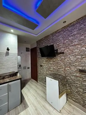 a living room with a brick wall and a tv at cozy studio in Kennaria, 1 min from Jemaa el-Fnaa in Marrakech