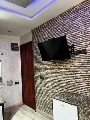 a flat screen tv hanging on a brick wall at cozy studio in Kennaria, 1 min from Jemaa el-Fnaa in Marrakech