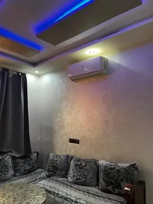 a living room with a couch and a tv on a wall at cozy studio in Kennaria, 1 min from Jemaa el-Fnaa in Marrakech