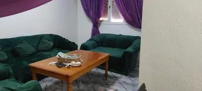 a living room with a green couch and a table at Apartment near train station Marrakesh in Marrakech
