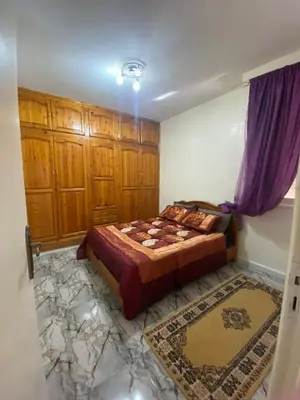 a bedroom with a bed and wooden cabinets at Apartment near train station Marrakesh in Marrakech
