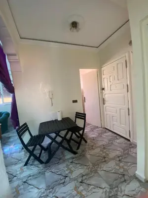 a room with two chairs and a table and a door at Apartment near train station Marrakesh in Marrakech