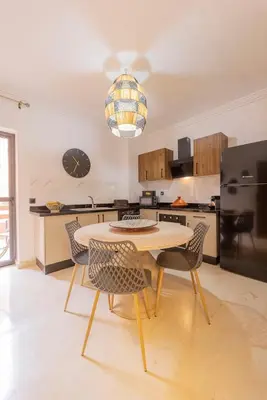 a kitchen with a table and chairs in a room at Sublime 3-bedroom duplex with pool in Marrakech