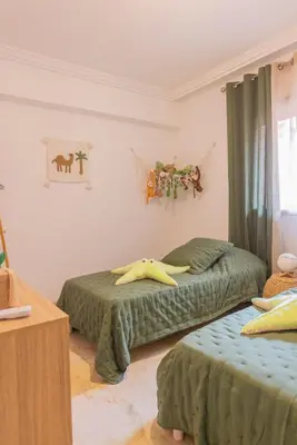 two beds in a room with green comforters at Sublime 3-bedroom duplex with pool in Marrakech