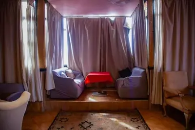 a living room with two chairs and a red table at GRAND HOTEL TAZi in Marrakech