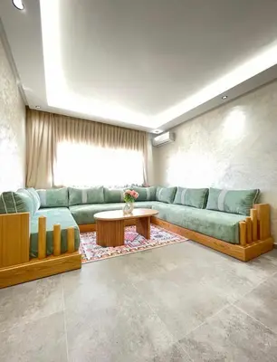a living room with a green couch and a table at Comfort Suites Marrakech in Marrakech