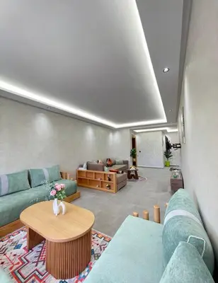 a living room with blue couches and a table at Comfort Suites Marrakech in Marrakech