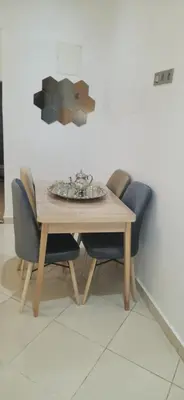 a dining room table with four chairs around it at Appartement Serein 10 min jamaa el fnaaa in Marrakech