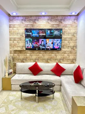 a living room with a couch with red pillows at Appartement Artiste in Marrakech