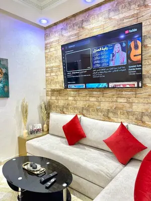 a living room with a couch and a tv at Appartement Artiste in Marrakech