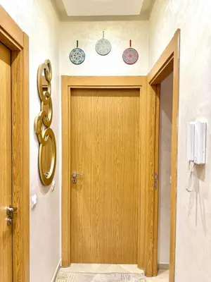 a wooden door in a hallway with plates on the wall at Appartement Artiste in Marrakech