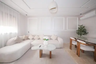 a white living room with a white couch and a table at Modern apartments, cozy residence, swimming pools in Marrakech