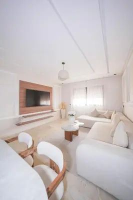 a living room with white furniture and a flat screen tv at Modern apartments, cozy residence, swimming pools in Marrakech