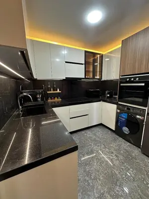a kitchen with white cabinets and black counter tops at new modern elite II apartment in Marrakech