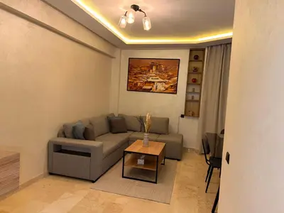 a living room with a couch and a table at Appart Cosy et confort en plein centre Marrakech in Marrakech